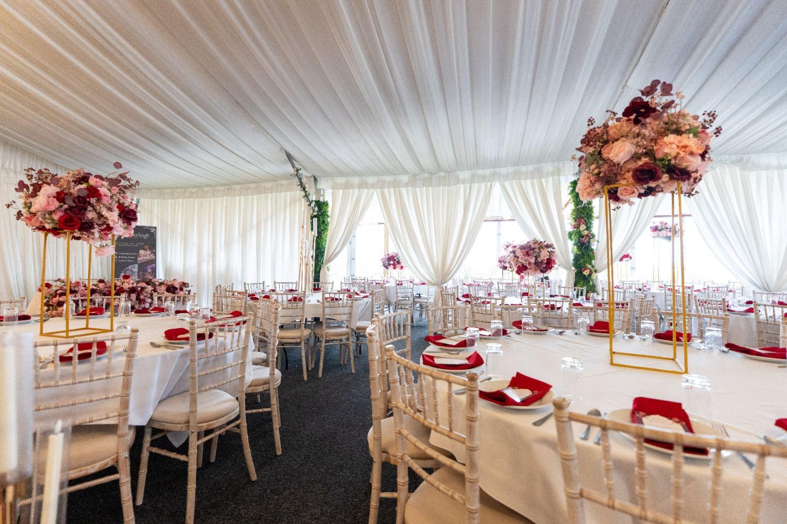 Elegant banquet hall set with burgundy and pink centerpieces