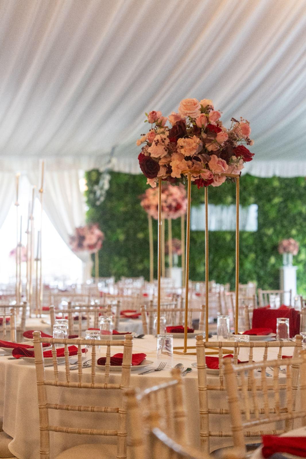 Coral and white floral centerpiece against hedge