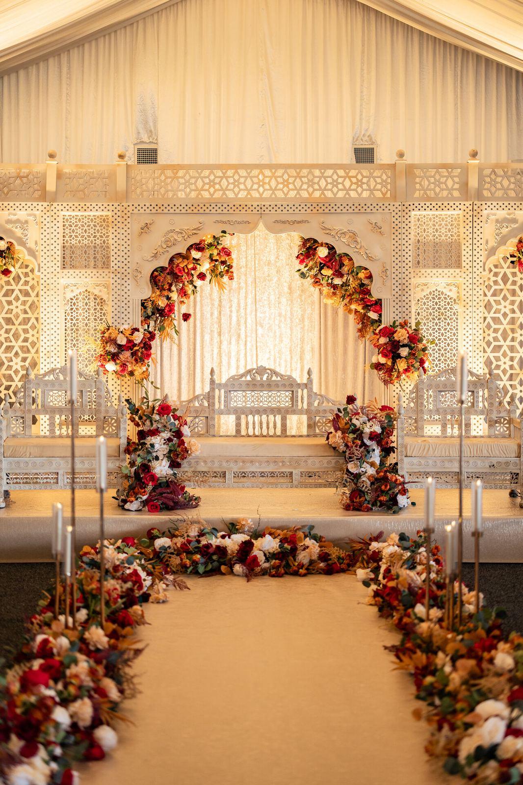 Ornate white mandap with arched floral decorations