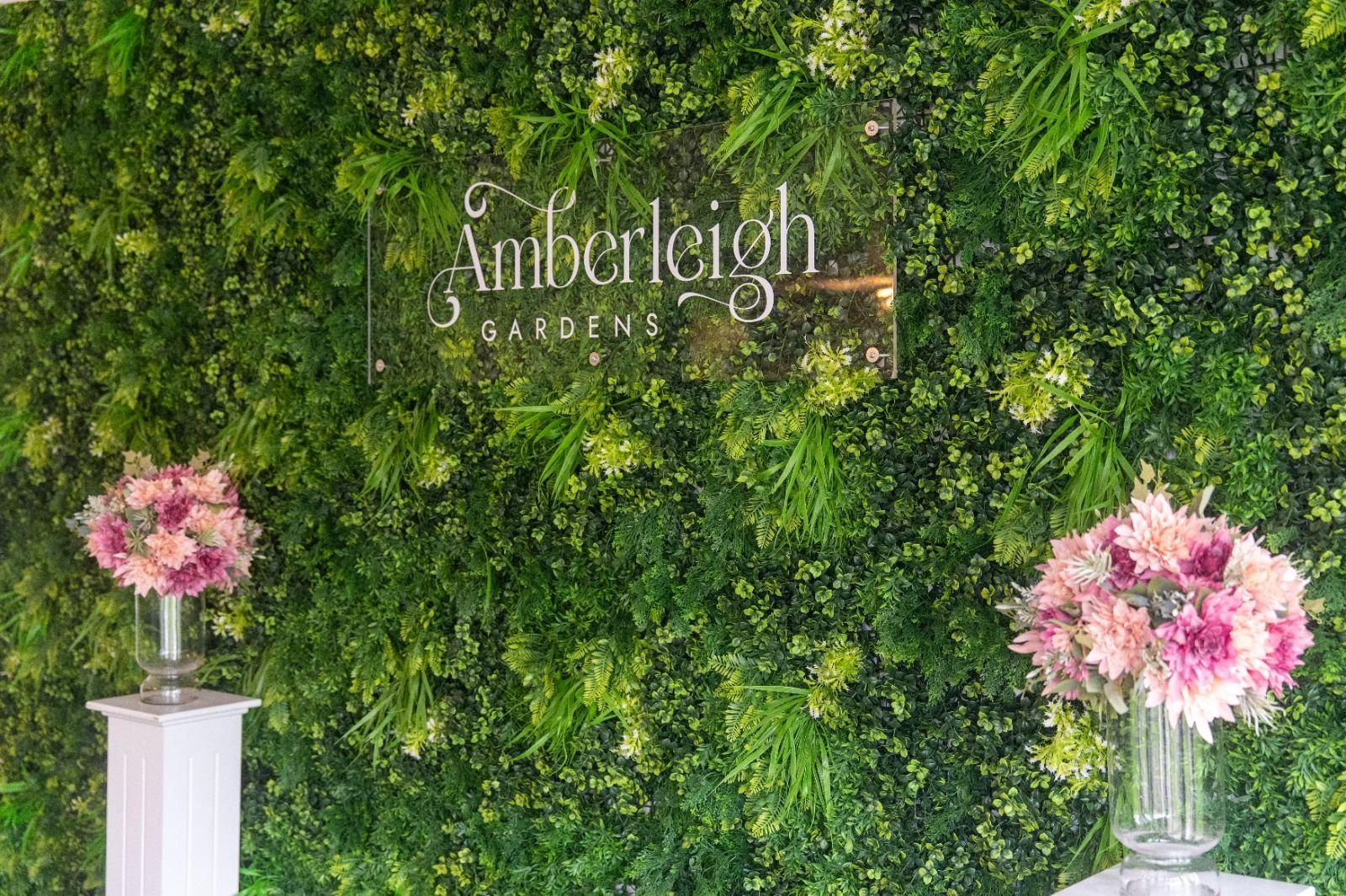 Amberleigh Gardens signage on lush greenery wall